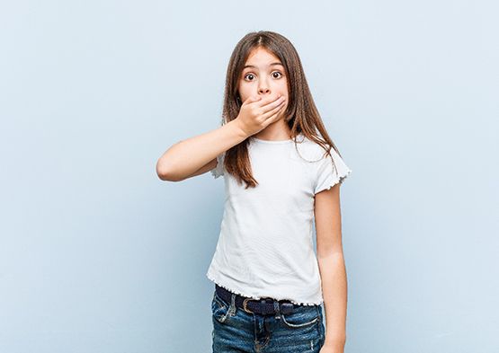 Little girl covering her mouth