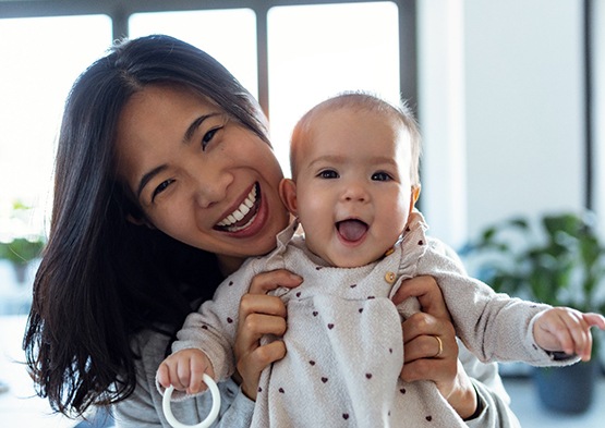 Happy mom holding her happy baby